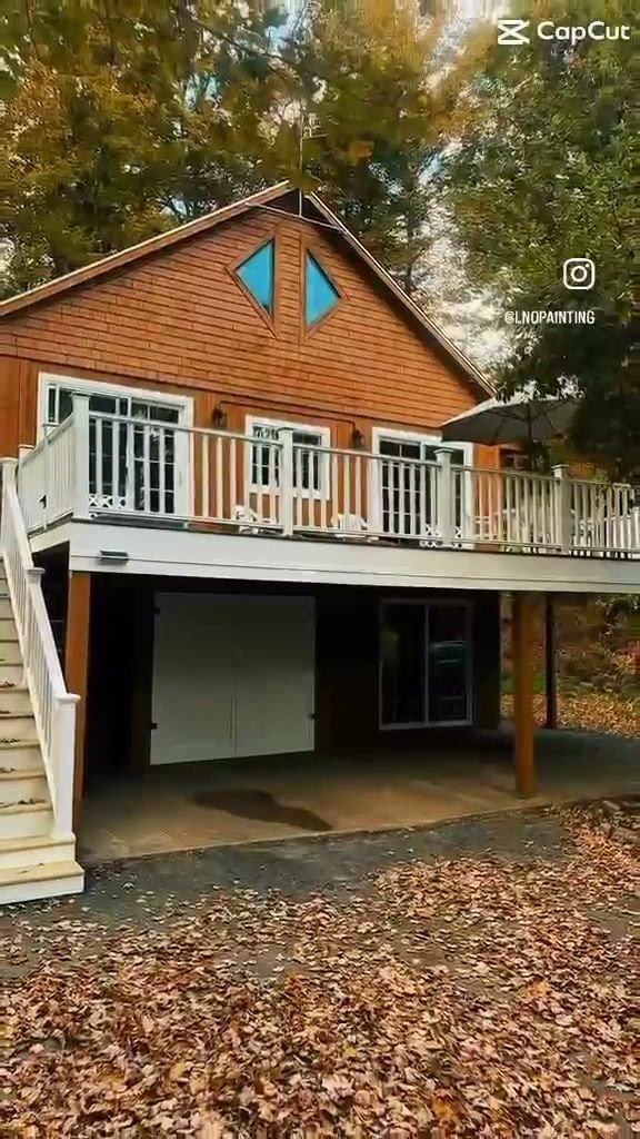 Wood-sided house with white deck railings in the fall