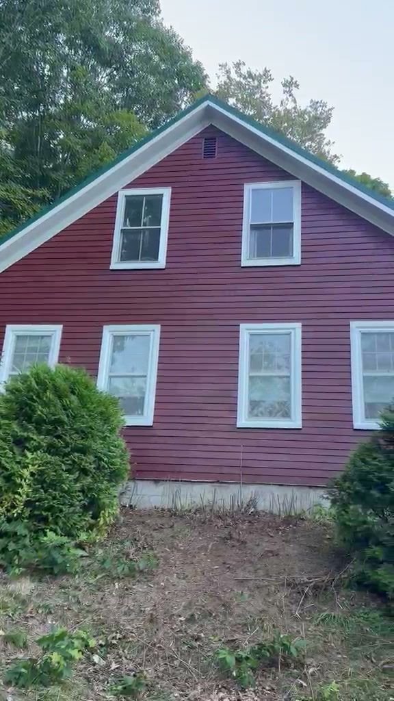 Clapboard farmhouse in deep red with white window trim